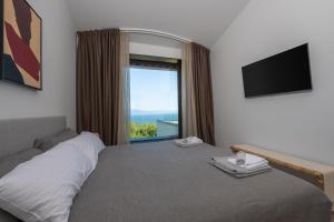1 dormitorio con 1 cama y ventana grande en Wild Adriatic Way, en Drenje