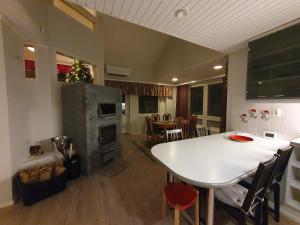 a kitchen and dining room with a white table and chairs at Lakeside Salmi in Rovaniemi