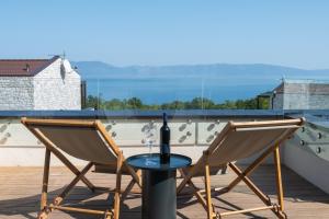 una mesa con una botella de vino en el balcón en Wild Adriatic Way, en Drenje