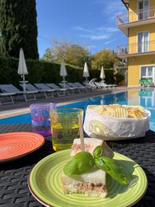 uma sanduíche num prato numa mesa perto de uma piscina em Bardolino City Life Apartments em Bardolino