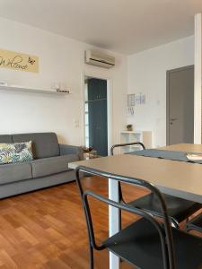uma sala de estar com um sofá, uma mesa e cadeiras em Bardolino City Life Apartments em Bardolino