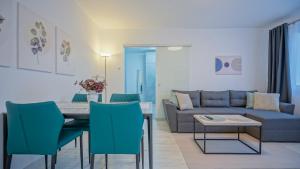 a living room with a couch and a table and chairs at Mountain Hideaway Apartment in Braşov