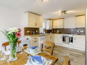 a kitchen with a table with a vase of flowers on it at 3 Bed in Bude 83223 in Marhamchurch