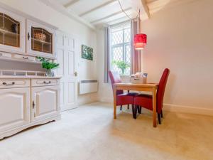 a dining room with a table and red chairs at 1 Bed in Cleobury Mortimer 82957 in Cleobury Mortimer