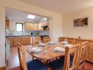 a kitchen with a wooden table with chairs and a dining room at 3 Bed in Threlkeld SZ083 in Threlkeld