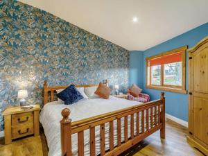 1 dormitorio con paredes azules, 1 cama y ventana en 3 bed in Bishop Auckland 87009 en Hunwick