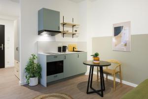 una cocina con una mesa pequeña en una habitación en POHA House Büchel, en Aachen