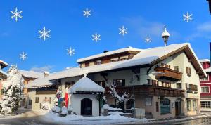 un edificio cubierto de nieve con copos de nieve en Ferienwohnung Andexlinger, en Abtenau