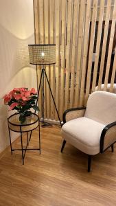 una sala de estar con una silla y una mesa con flores en Hosteria Tajahierro, en Reinosa