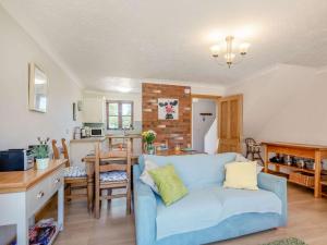 a living room with a blue couch and a kitchen at 2 Bed in Happisburgh 88981 in Honing