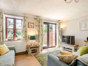 a living room with a couch and a tv at 2 Bed in Happisburgh 88981 in Honing
