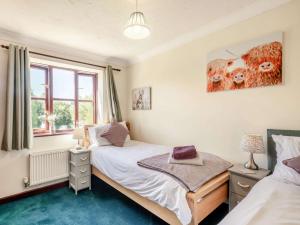 a bedroom with two beds and a window at 2 Bed in Happisburgh 88981 in Honing