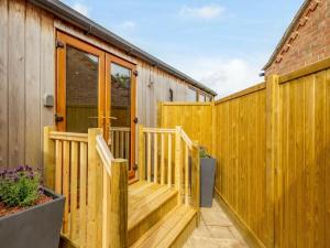 a wooden deck next to a wooden fence at 1 Bed in Burnham Market 88221 in Burnham Market