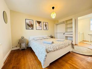 um quarto com uma cama e piso em madeira em Maison des chenizelles em Laon