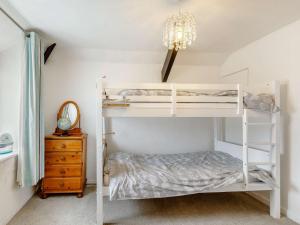 um quarto com um beliche branco e um lustre em 3 Bed in Hartland 88143 em Hartland