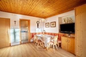a dining room with a table and chairs and a television at App Hubertus - Sagernock in Sand in Taufers +7 photos