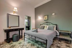 a bedroom with a bed and a mirror and a piano at Boho Rooms Sliema in Sliema