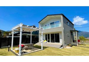 une maison avec une pergola sur une pelouse dans l'établissement [Mt, Fuji koko] Newly built rental villa with dogs - Vacation STAY 26673v, à Fujikawaguchiko