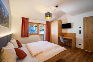 een slaapkamer met een bed en een bureau. bij App Hubertus - Wasserfallspitz in Sand in Taufers
