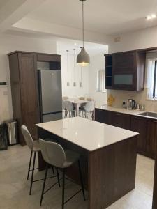 a kitchen with a white island in a kitchen with chairs at Elegant Maisonette in Malta by AssetFlow PRO in Marsaskala