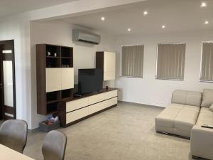 a living room with a couch and a flat screen tv at Elegant Maisonette in Malta by AssetFlow PRO in Marsaskala