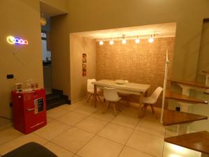 una sala da pranzo con tavolo, sedie e frigorifero rosso di Senza Pressa b&b a Portici