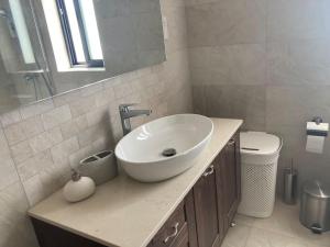 a bathroom with a white sink and a toilet at Elegant Maisonette in Malta by AssetFlow PRO in Marsaskala
