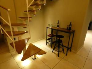 um pequeno quarto com um bar com um banco e garrafas de vinho em Senza Pressa b&b em Portici