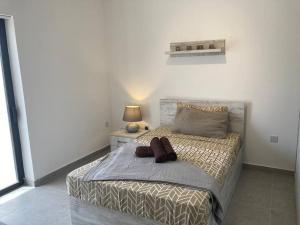 a bedroom with a large bed with a lamp and a bed sidx sidx at Elegant Maisonette in Malta by AssetFlow PRO in Marsaskala