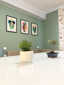 a white table with two potted plants in a room at "Il Garibaldi" - Appartamento intero o stanze! in Reggio di Calabria