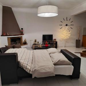 Un dormitorio con una cama y un reloj en la pared. en Sweet Dreams Trikala, en Tríkala