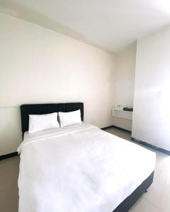 Schlafzimmer mit einem großen weißen Bett in der Unterkunft KS Hotel in Cilacap