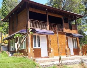 Casa de madera con balcón en la parte superior. en NK Villa Syariah And Cafe Prigen en Pasuruan