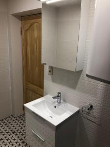 La salle de bains est pourvue d'un lavabo blanc et d'une armoire. dans l'établissement Dzīvoklis Bocmaņa laukums 2, Salacgrīva, à Salacgrīva