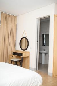 1 dormitorio con cama, espejo y lavamanos en Luxurious Penthouse With Luxurious Pool, en Takoradi