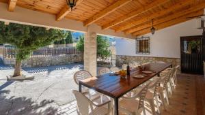 une table et des chaises en bois sur une terrasse dans l'établissement Casa de Paquita Montefrio by Ruralidays, à Montefrío