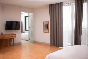 ein Schlafzimmer mit einem Bett, einem Spiegel und einem TV in der Unterkunft Luxurious Penthouse With Luxurious Pool in Takoradi