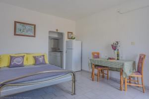 a bedroom with a bed and a table and a refrigerator at Kob Orog good location with sea views and modern decor in Metajna