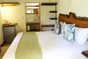 una camera da letto con un grande letto bianco con due cuscini di La Kruger Lifestyle Lodge - No Loadshedding a Marloth Park