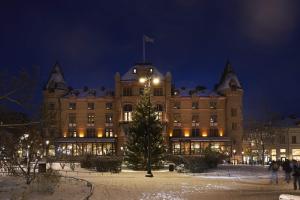 un gran edificio con un árbol de Navidad delante de él en Grand Hotel Lund, en Lund