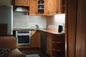 a kitchen with wooden cabinets and a stove top oven at Viljandi Jahiloss in Viljandi