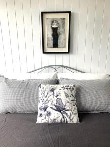 a bed with a pillow and a picture on the wall at Bridairre in Bridport