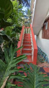 a stairway with a red railing next to a building at Delight Homestays Coorg in Kushālnagar