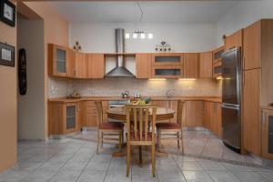 a kitchen with wooden cabinets and a table and chairs at Idalia Nature Haven, Three-Bedroom Apartment in Kournás