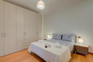 a white bedroom with a bed and white cabinets at Magnolia - Happy Rentals in Laveno-Mombello