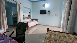 a room with a bedroom with a bed and a tv at Delight Homestays Coorg in Kushālnagar