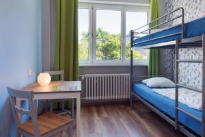 um pequeno quarto com uma secretária e beliches em Patio Hostel Dorms em Bratislava