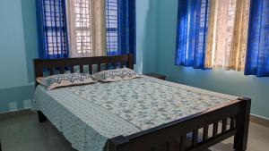 uma cama num quarto com paredes e janelas azuis em Delight Homestays Coorg em Kushalanagar