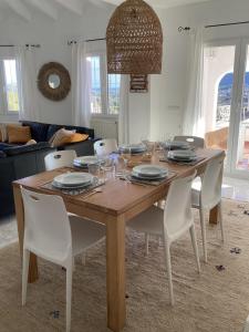 mesa de madera con sillas blancas y comedor en Casa La Vida, stijlvolle Spaanse villa met uniek uitzicht!, en Benitachell