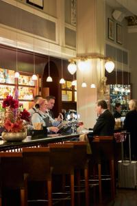 un grupo de personas sentadas en un bar en Grand Hotel Lund, en Lund